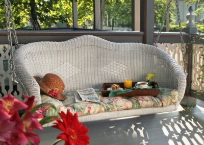 Close-up photo of the Lord Melbourne private porch wicker swing