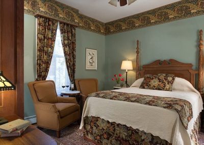 Photo of the Balmoral bedroom with the rich brown, rust, teal and gold floral bedding and draperies.