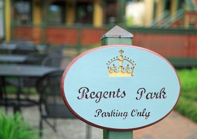 Photo of an oval green and burgundy "Regents Park Parking Only " sign