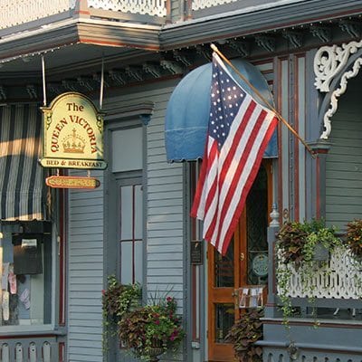 The front entrance of the House of Royals building with the American flag flying above the lush flower boxes