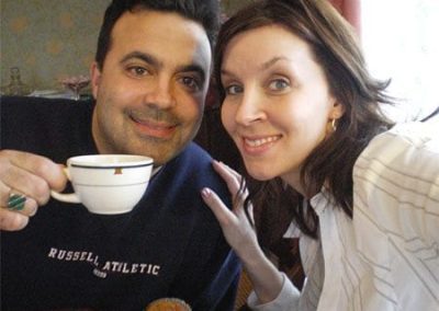 Guest Photos- Closeup of young couple smiling. Man holding coffee cup.