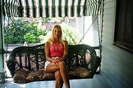 Guest Photos- woman sitting on porch swing at Queen Victoria Bed and Breakfast