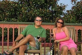 Guest Photos- Smiling couple on porch drinking wine at Queen Victoria.